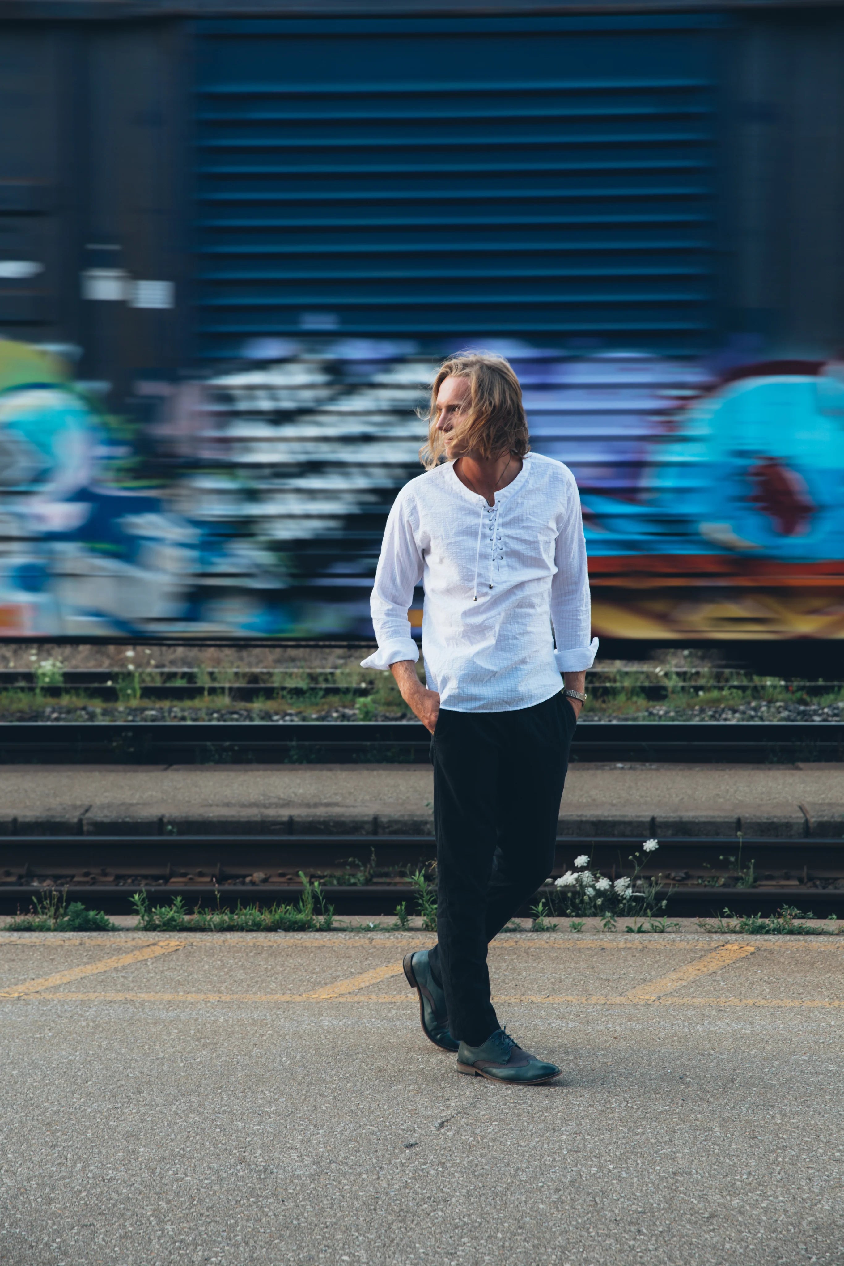 files/fashionable-man-walks-by-train-tracks.webp